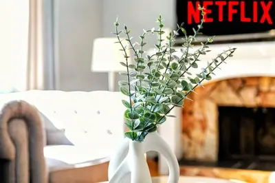a white vase with flowers in it on a table at Comfy Getaway - Walk to West Ed Mall in Edmonton