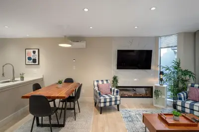 a living room with a table and chairs and a fireplace at 1BR plus Two Dens in The Gables, Epic Location Near Gondolas, Private Balcony, Fireplace, Parking in Whistler