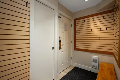 a hallway with wooden walls and a door at 1BR plus Two Dens in The Gables, Epic Location Near Gondolas, Private Balcony, Fireplace, Parking in Whistler