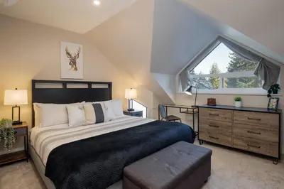 a bedroom with a large bed and a window at 1BR plus Two Dens in The Gables, Epic Location Near Gondolas, Private Balcony, Fireplace, Parking in Whistler