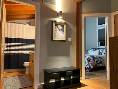 a bathroom with a toilet and a room with a bed at Along the Way in Youbou