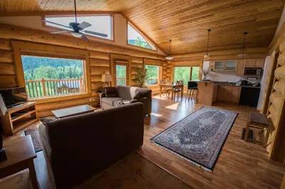 a living room with a ceiling fan and a kitchen at Alpine Meadows Resort in Clearwater