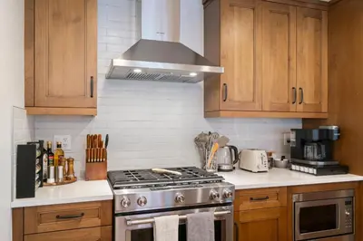 a kitchen with wooden cabinets and a stove top oven at Timberstone Condo by Canadian Rockies Vacation Rentals in Canmore