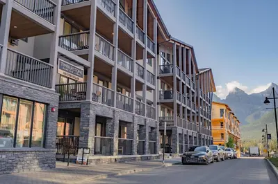 a building with cars parked on the side of a street at Timberstone Condo by Canadian Rockies Vacation Rentals in Canmore