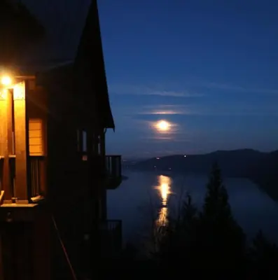 a full moon rising over a lake at night at Moon Water Lodge in Malahat