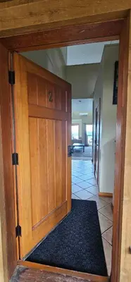 a large wooden door in a room with a rug at Moon Water Lodge in Malahat