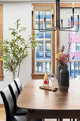 a dining room table with a chandelier at New Spacious Mountain View Condo in Canmore With Hot Tub, Park Pass, Prime Location in Canmore