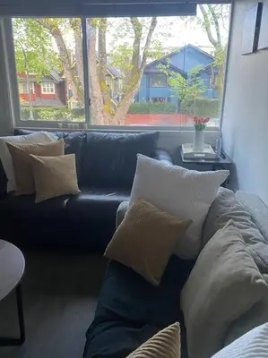 a living room with a blue couch and a window at Quiet-comfy 4 bedroom house on a quiet tree lined street in Kitsilano in Vancouver