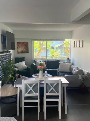 a living room with a couch and a table and chairs at Quiet-comfy 4 bedroom house on a quiet tree lined street in Kitsilano in Vancouver