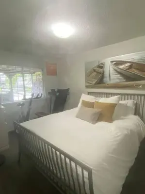 a bedroom with a bed with white sheets and pillows at Quiet-comfy 4 bedroom house on a quiet tree lined street in Kitsilano in Vancouver