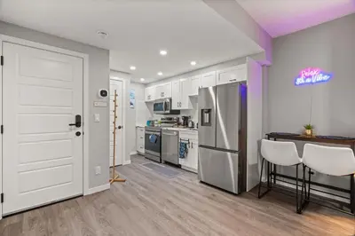 a kitchen with white cabinets and a refrigerator at Meriweather - Calgary Breathtaking 1-bedroom apartment in Calgary