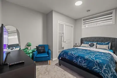 a bedroom with a blue bed and a blue chair at Meriweather - Calgary Breathtaking 1-bedroom apartment in Calgary