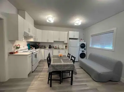a kitchen with a table and chairs and a couch at Two Bedroom Suite Burnaby Metrotown in Burnaby