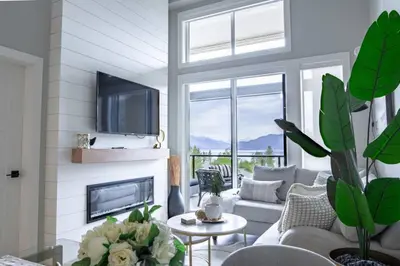 a living room with a couch and a fireplace at Brand New Penthouse with Lake and Mtn Views in Harrison Hot Springs