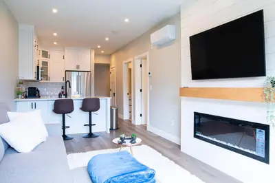 a living room with a fireplace and a flat screen tv at New 1 Bed Condo with Mtn Views in Harrison Hot Springs