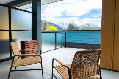 two chairs on a balcony with a view of the mountains at New 1 Bed Condo with Mtn Views in Harrison Hot Springs