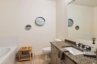 a bathroom with a sink and a toilet and a mirror at Condo at Barona Beach Lakeside Resort in West Kelowna