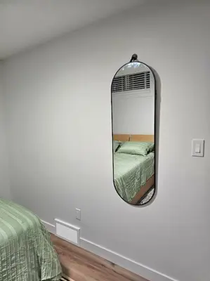 a mirror on a wall in a bedroom at Cozy 2 bedrooms and 1 bath for 4 guests! in Calgary