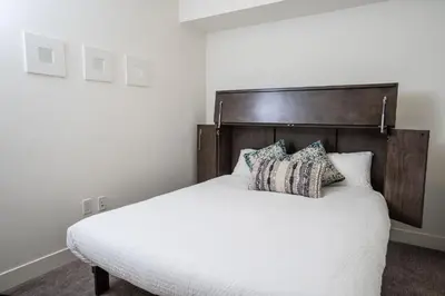 a bedroom with a white bed with pillows on it at L'Austin Rêve by Revelstoke Vacations in Revelstoke
