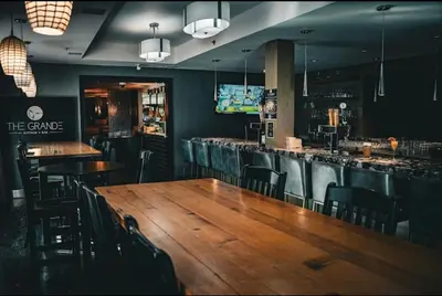 a restaurant with a wooden table and chairs and a bar at Cozy One Bedroom Condo with Indoor Pool and HotTub in Canmore