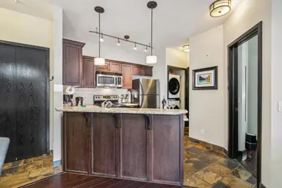 a kitchen with wooden cabinets and a counter top at Cozy One Bedroom Condo with Indoor Pool and HotTub in Canmore