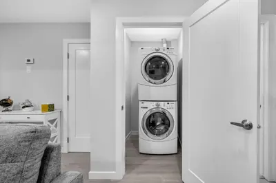 a laundry room with a washer and dryer in it at Modern & Spacious Guest Suite in Calgary