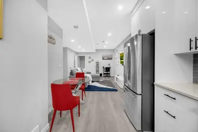 a kitchen and living room with a table and a refrigerator at Modern & Spacious Guest Suite in Calgary