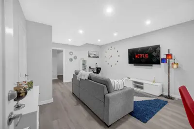 a living room with a couch and a tv at Modern & Spacious Guest Suite in Calgary