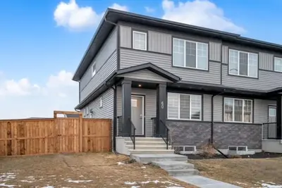 a gray house with a wooden fence in front of it at Modern & Spacious Guest Suite in Calgary