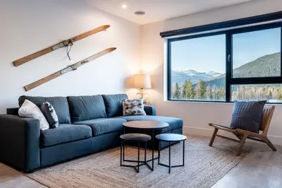 a living room with a blue couch and a table at Drop in Condo by Revelstoke Vacations in Revelstoke