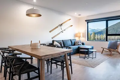 a living room with a table and chairs and a couch at Drop in Condo by Revelstoke Vacations in Revelstoke