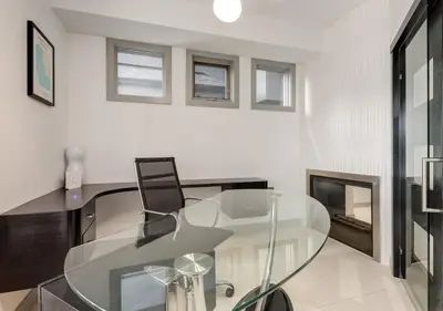 a glass table with a chair in a room at Newly Renovated Vacation Home w/ Hot Tub & Garage in Calgary