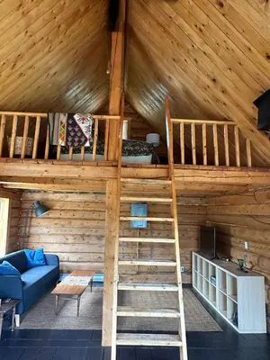 a room with two bunk beds and a couch at Dry Log Cabin with Mountain Views in Upper Laberge