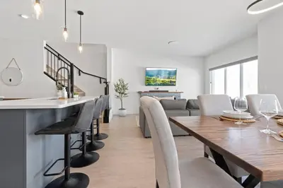 a dining room and living room with a table and chairs at Family Home Retreat - 9 mins to WEM - Vintage Arcade-Ping Pong -Air Conditioning in Edmonton