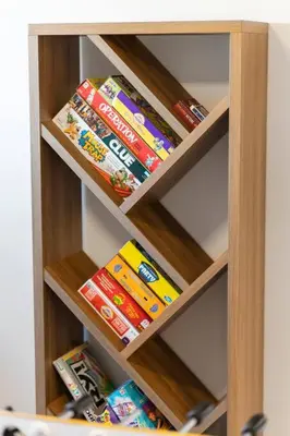 a wooden book shelf with toy cars on it at Family Home Retreat - 9 mins to WEM - Vintage Arcade-Ping Pong -Air Conditioning in Edmonton