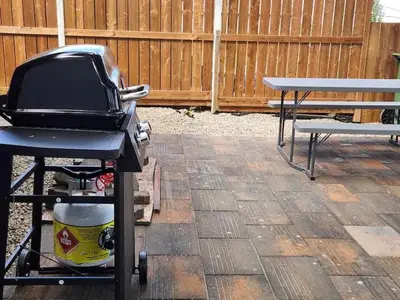 a grill on a cart next to a bench at Centre Street 2bed Upper Suite - 4408 in Calgary
