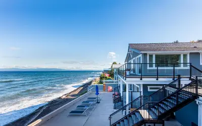a house with stairs leading down to the beach at Qualicum Beach Ocean Suites in Qualicum Beach