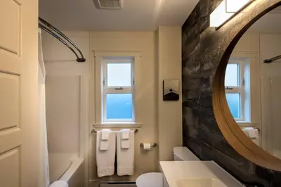 a bathroom with a sink and a mirror at Qualicum Beach Ocean Suites in Qualicum Beach