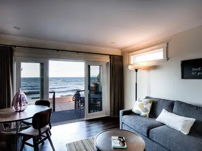a living room with a couch and a view of the ocean at Qualicum Beach Ocean Suites in Qualicum Beach