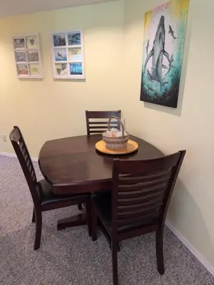 a dining room table with two chairs and a whale painting at Gabriola Island B&B By The Sea in Gabriola