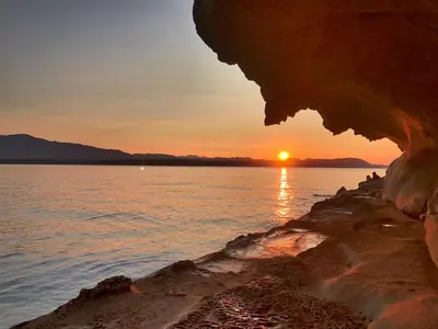 a sunset over a body of water with the sun setting at Gabriola Island B&B By The Sea in Gabriola