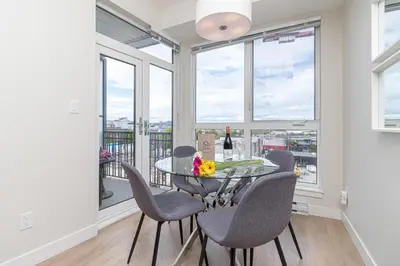 a dining room with a table and chairs and windows at A Gem In This Cityzen Hideaway in Victoria