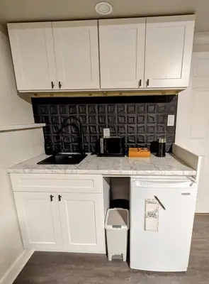 a kitchen with white cabinets and a counter top at By the Sea in Campbell River