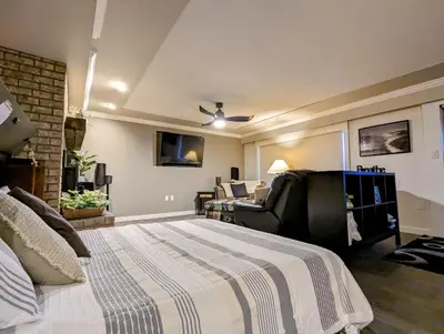 a bedroom with a large bed and a living room at By the Sea in Campbell River