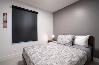 a bedroom with a bed with a large screen on the wall at Summit Views Condo by Revelstoke Vacations in Revelstoke