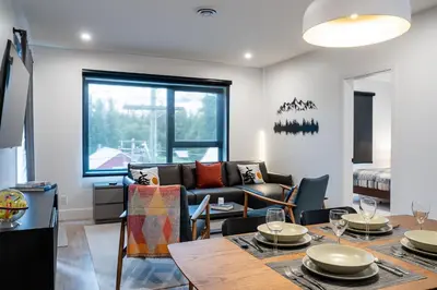 a living room with a couch and a table at Summit Views Condo by Revelstoke Vacations in Revelstoke