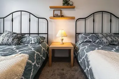 a bedroom with two beds and a table with a lamp at LovelyHome-Foosball-NearAirport-5 Queen Beds -Air conditioning in Edmonton
