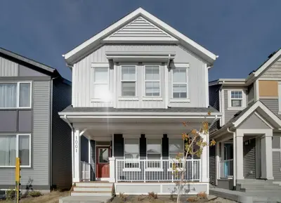 a white house with a porch at LovelyHome-Foosball-NearAirport-5 Queen Beds -Air conditioning in Edmonton