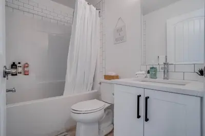 a white bathroom with a toilet and a sink at LovelyHome-Foosball-NearAirport-5 Queen Beds -Air conditioning in Edmonton