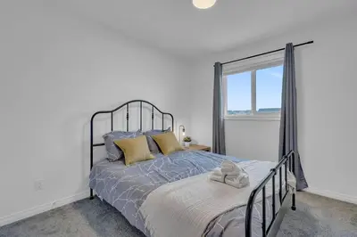 a bedroom with a bed and a window at LovelyHome-Foosball-NearAirport-5 Queen Beds -Air conditioning in Edmonton